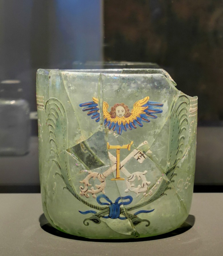 Historisches Gefäß aus grünlichem Glas und mit fargiben Bemalungen.