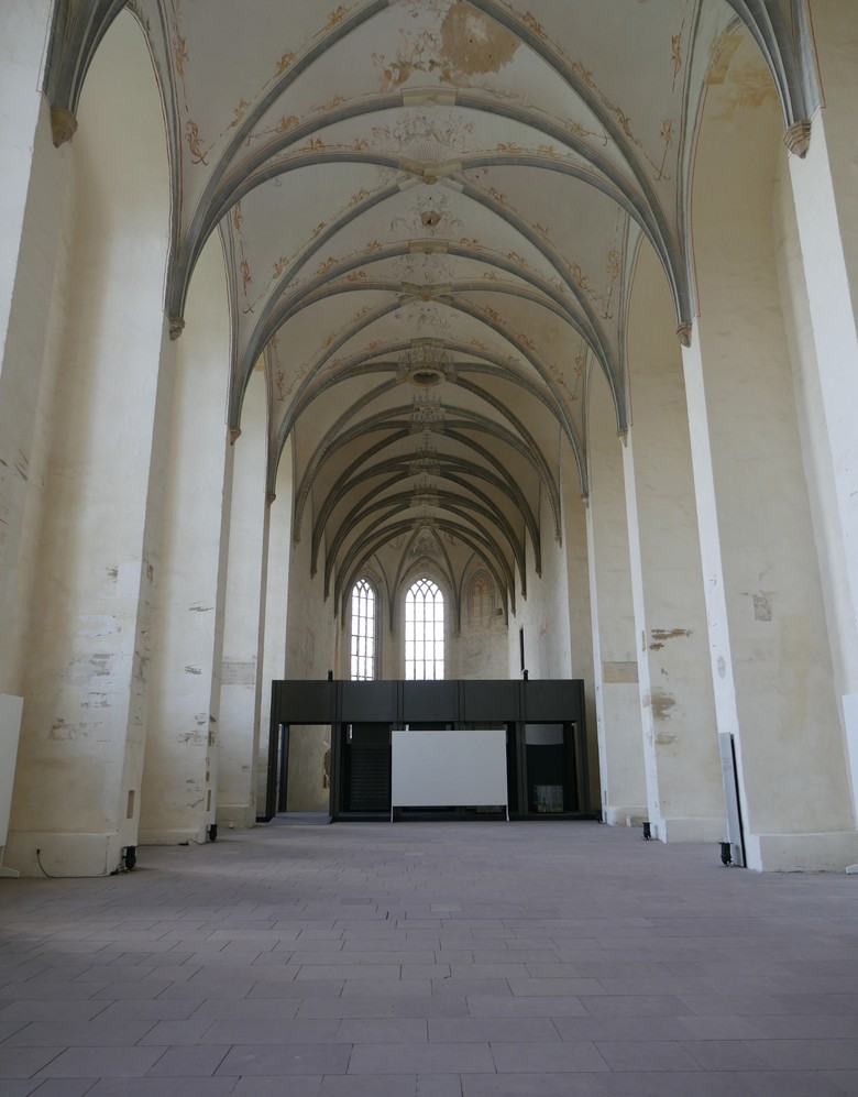 Blick in den Dalheimer Kirchenraum mit verziertem Gewölbe und einem modern anmutenden Lettner.